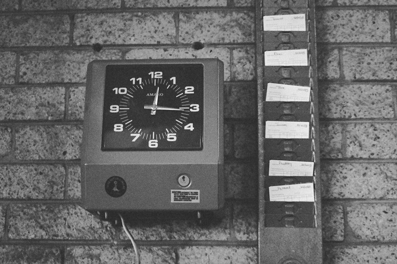 A wall-mounted employee time clock and punch cards