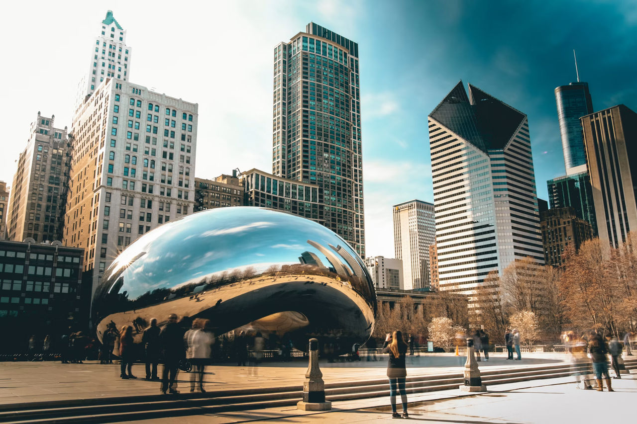 Cloud Gate in Millennium Park reflecting visitors and the Chicago skyline