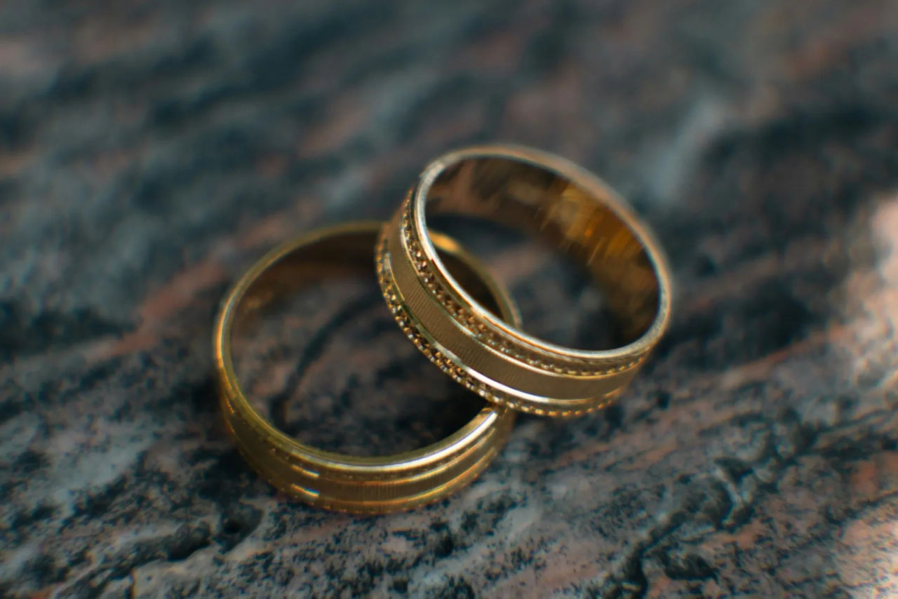 Two wedding rings resting on a stone surface