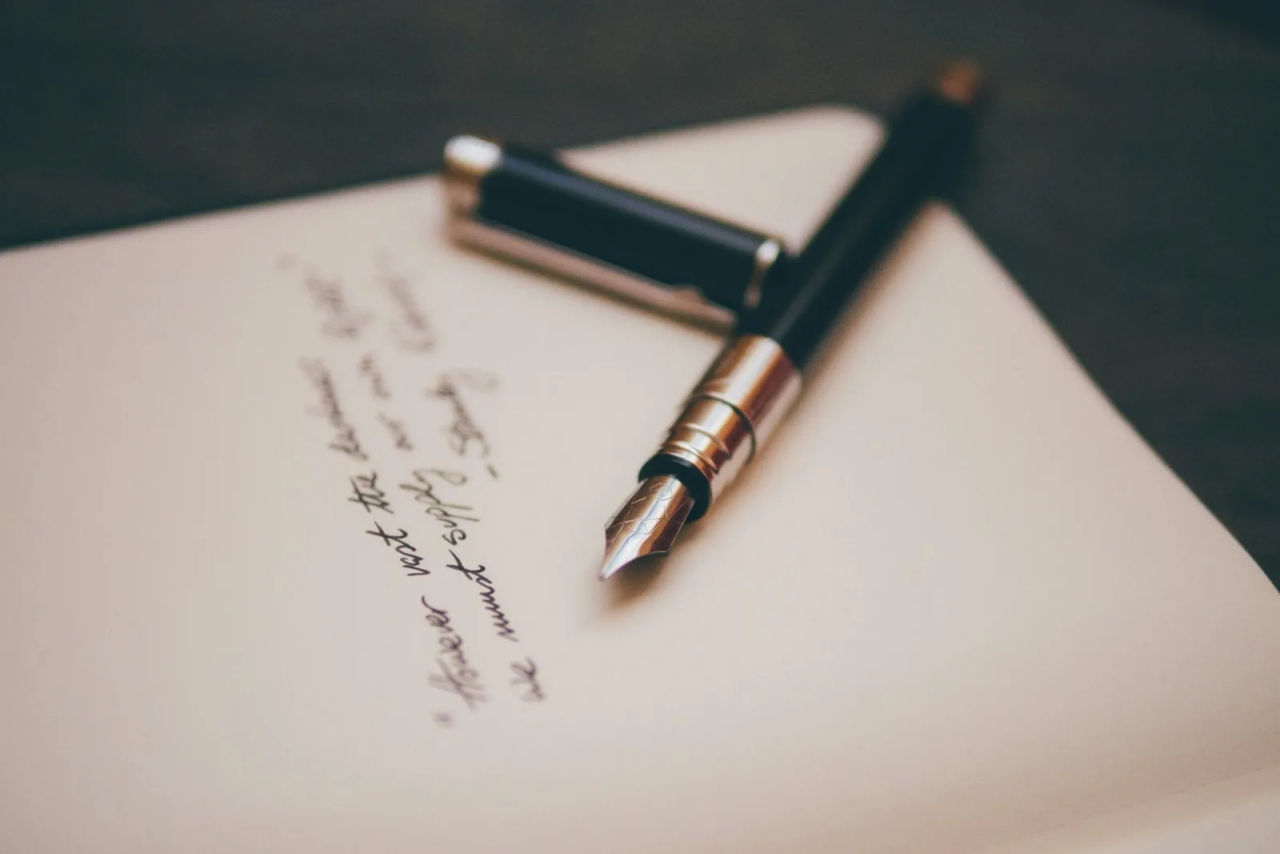 A fountain pen resting on a handwritten page