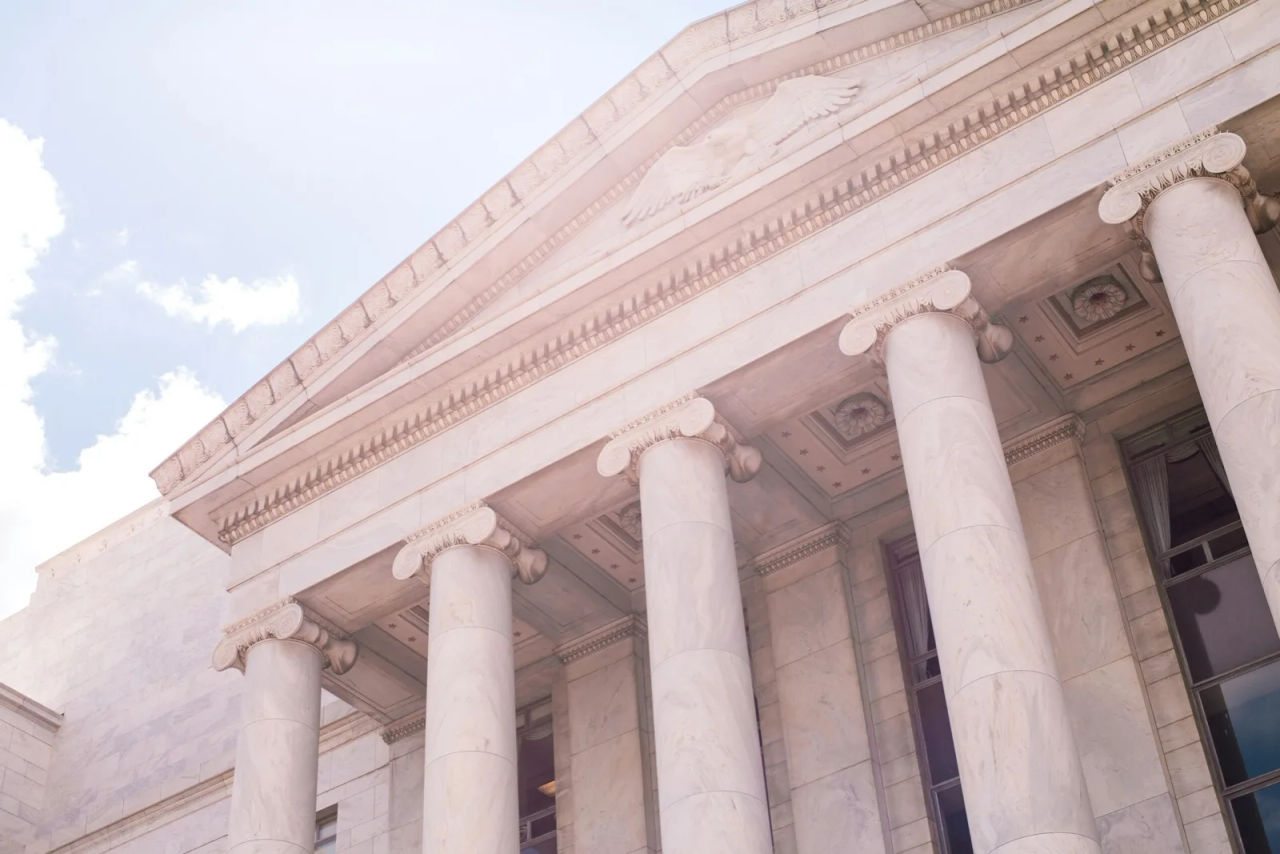 The marble pediment and columns of a courthouse, an eagle carved above