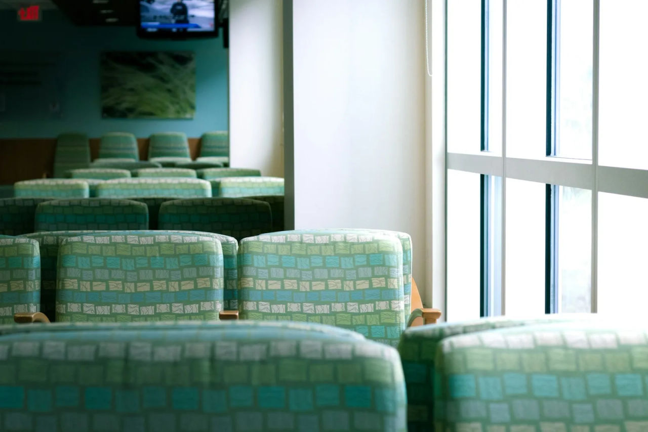 An empty hospital waiting room beside tall windows