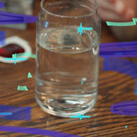 Photo of a clear glass of water on a wooden table with blue graphic accents.