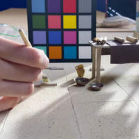 A close-up photo of an artists hand shaping small items used on the set of Sermon on the Mount.