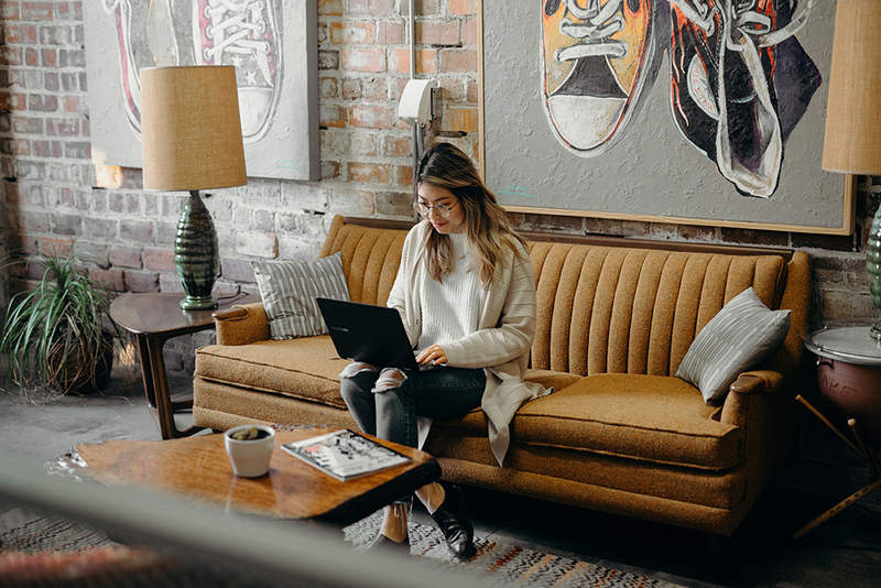 A person sitting on a couch using a laptop