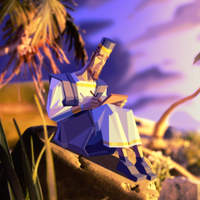 Illustration of a bearded man in blue robes and a tall hat, writing on a tablet while seated among rocks and palm fronds at sunset.