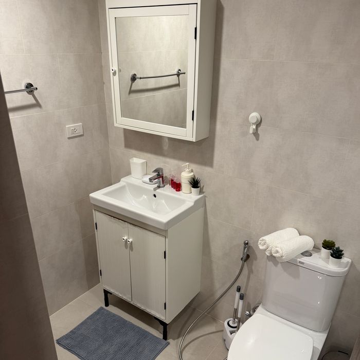 Modern bathroom with shower, mirror cabinet, built-in shelves, hair dryer