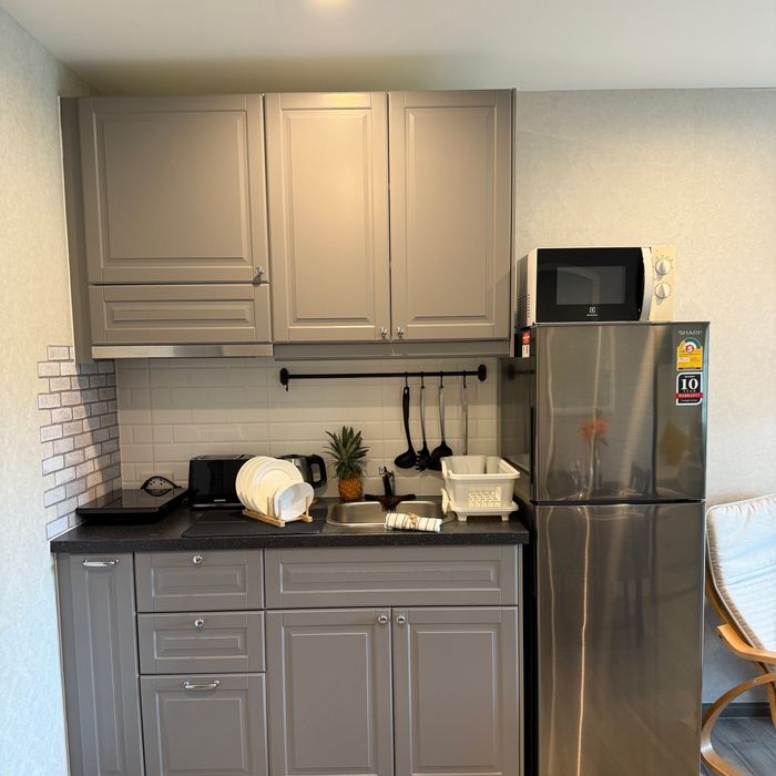 Общее фото кухонной зоны: индукционная плита, тостер, чайник, СВЧ-печь