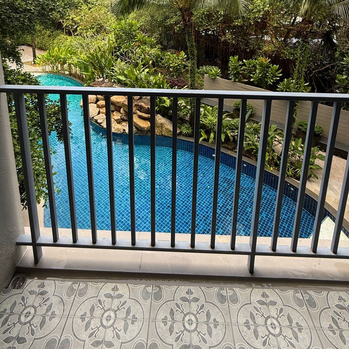 3 sqm balcony with pool view, afternoon sun, palm trees and garden surroundings