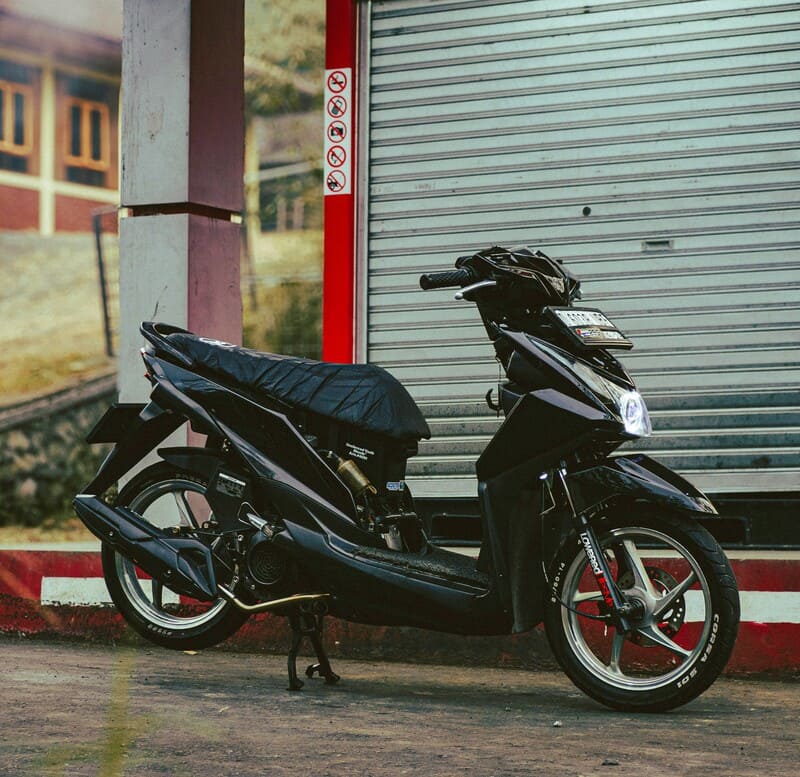 Sebuah motor matic sewaan sedang mengisi bensin karena mogok di tengah jalan