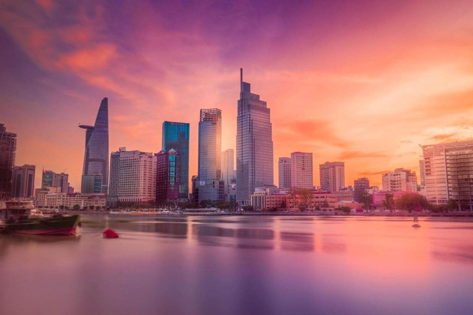 Đường chân trời Sài Gòn lúc hoàng hôn với các tòa nhà hiện đại phản chiếu trên dòng sông yên ả