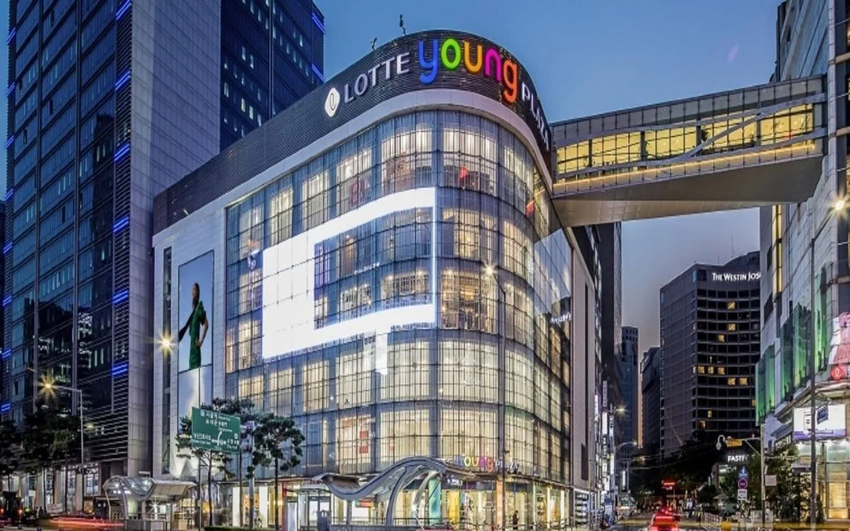 Seoul street at night illuminated by neon lights with bustling pedestrians and bright storefronts.