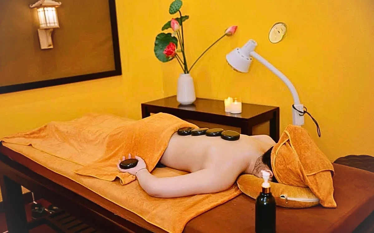 Khách hàng nằm thư giãn được kỹ thuật viên spa trị liệu giảm đau mỏi chuyên sâu