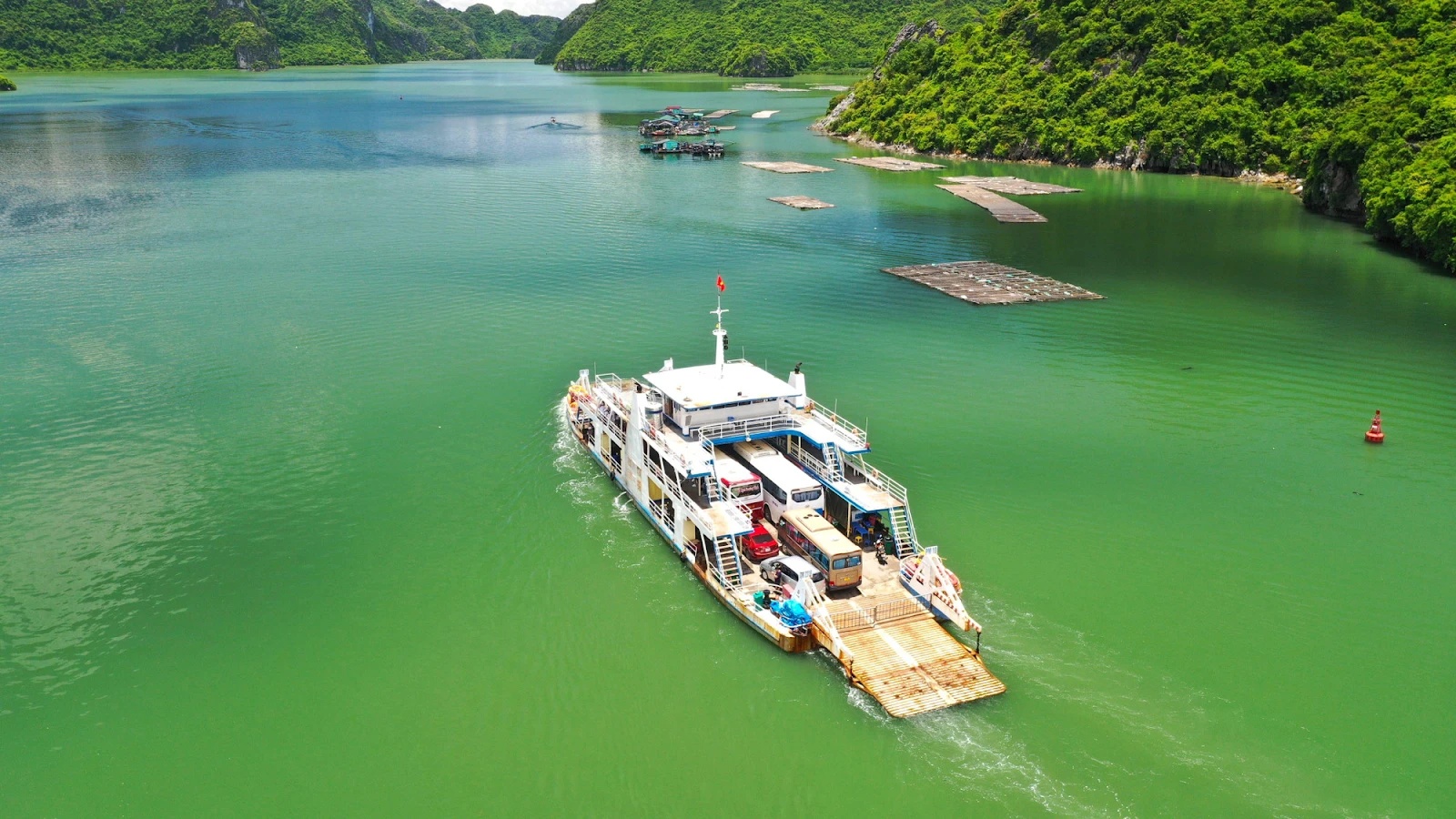 A ferry carrying visitors from Ha Long to Cat Ba Island passes through Lan Ha Bay with limestone islands on the sea