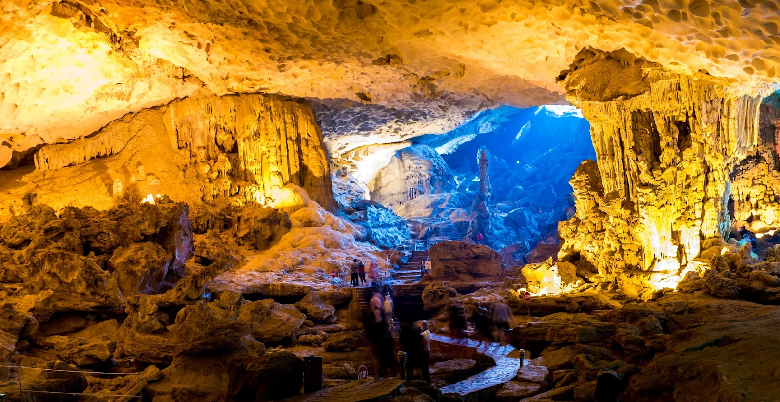 Inside Sung Sot Cave in Ha Long Bay with large stalactites and illuminated lighting system