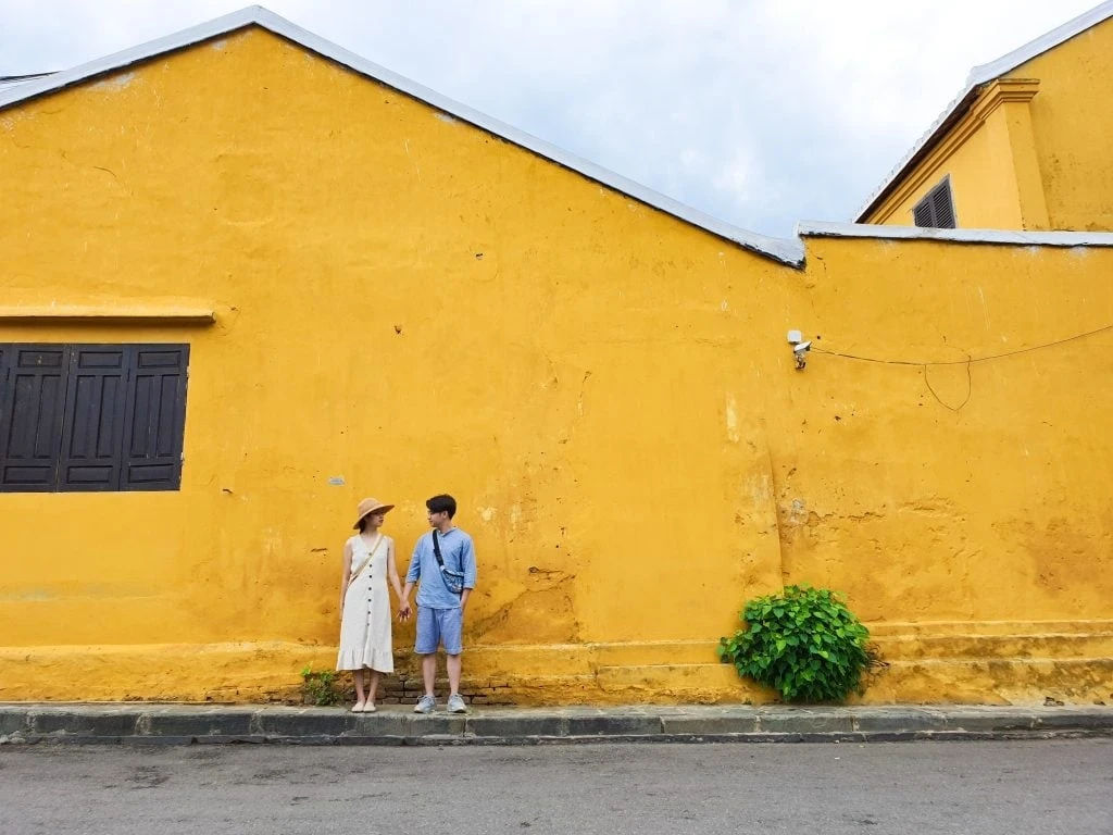 Du khách chụp ảnh bức tường vàng đặc trưng ở Hội An