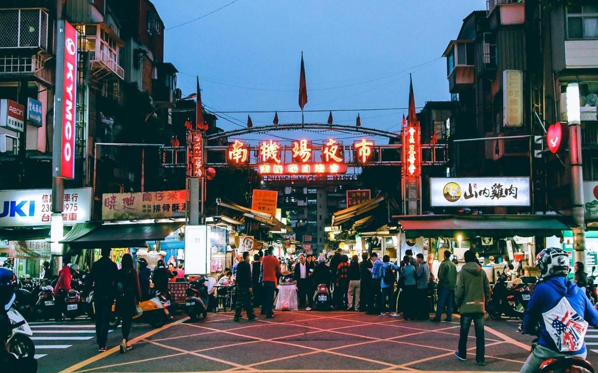 The Nanjichang night market gate was brightly lit with red lights, and numerous stalls and crowds of people bustled below.