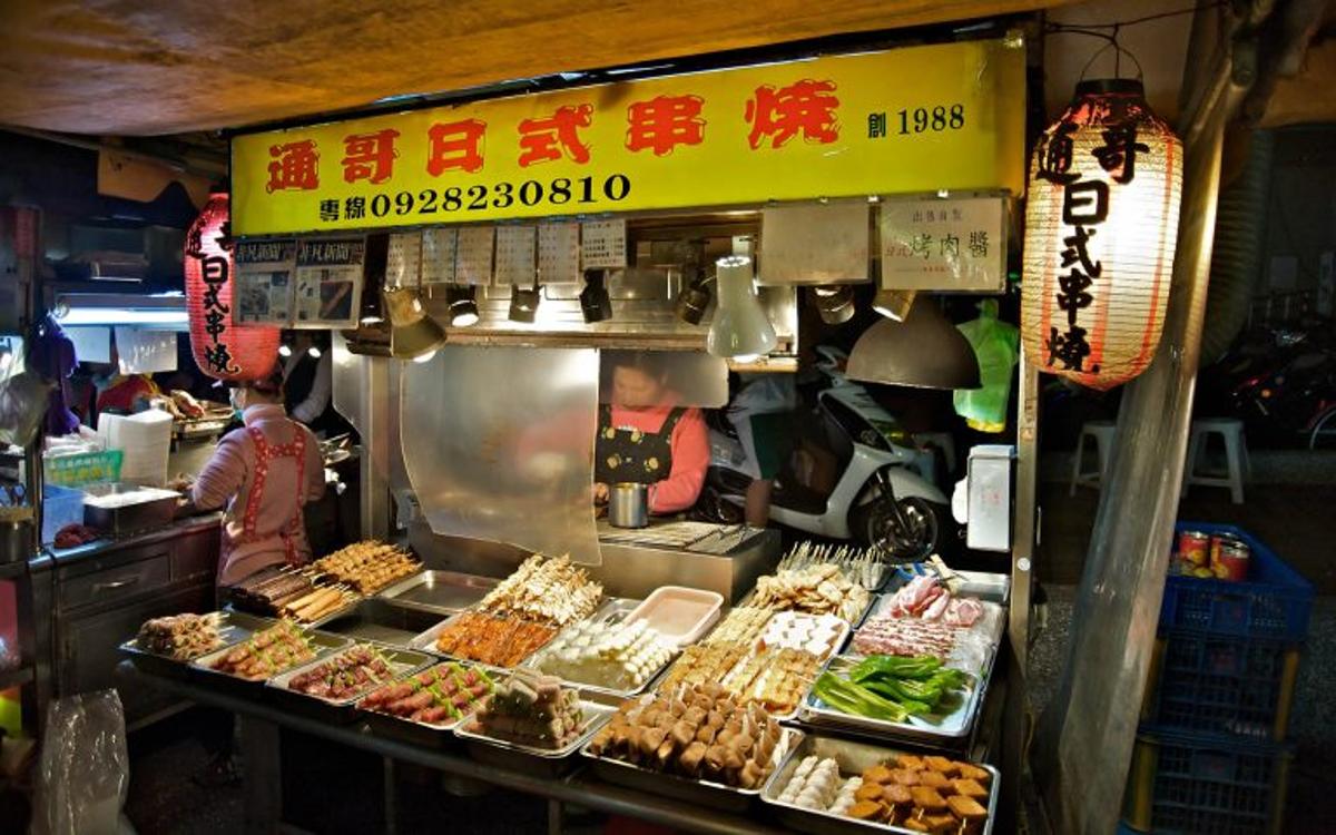 A skewer stall in a Taiwanese night market displays a variety of meats, vegetables, and seafood.