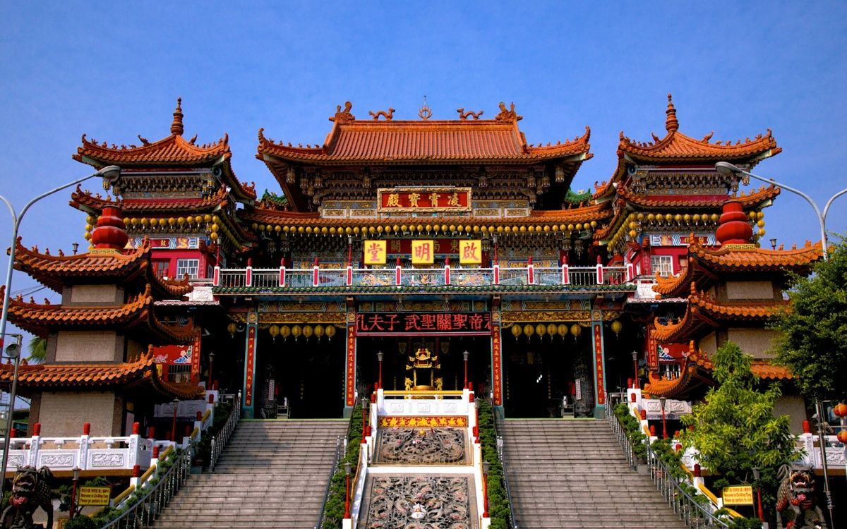 Hình ảnh đền thờ Mazu với kiến trúc nhiều tầng, mái ngói cong đỏ vàng, cổng lớn trang trí chữ Hán và bậc thang dẫn lên điện chính uy nghi.