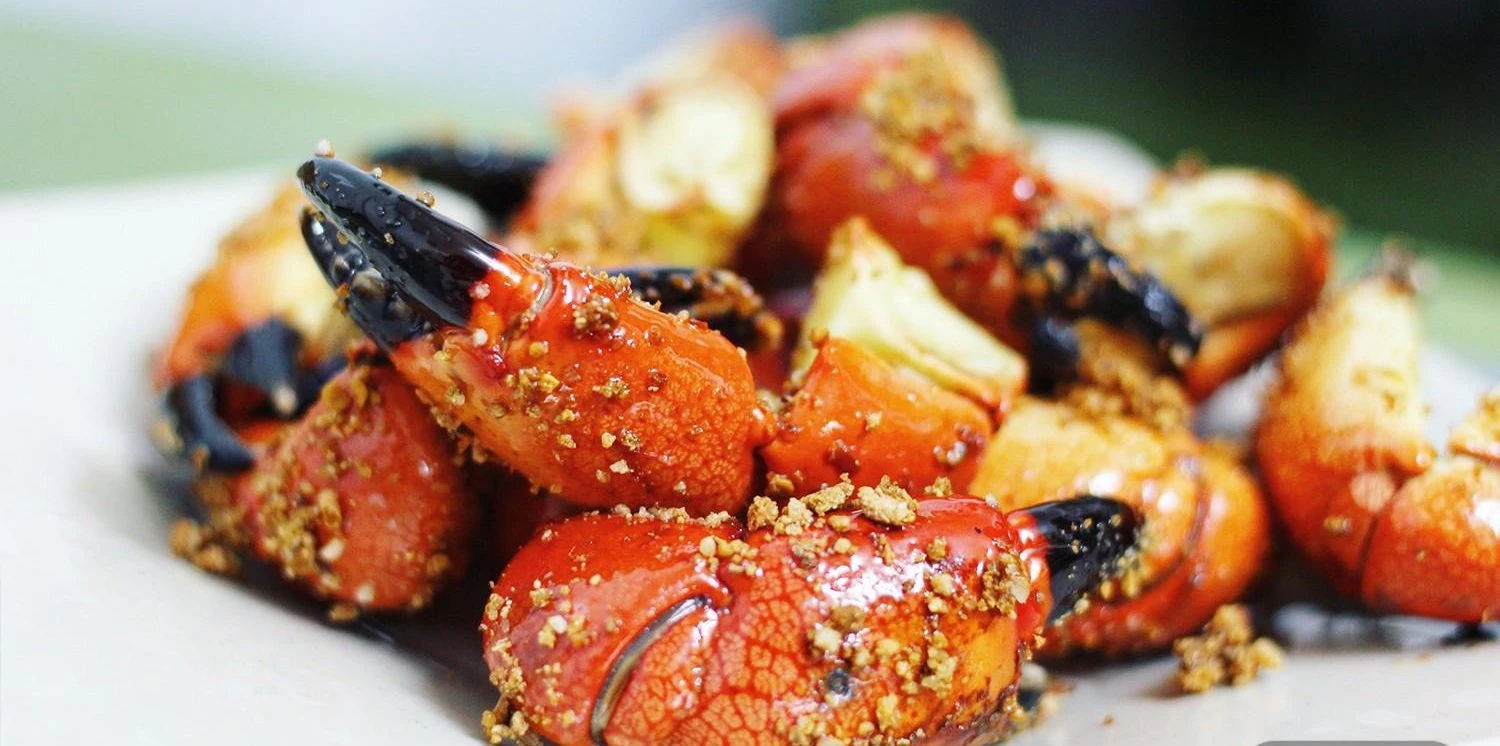 Quang Ninh stone crab with a vibrant orange-red hue, coated in sweet and sour tamarind sauce