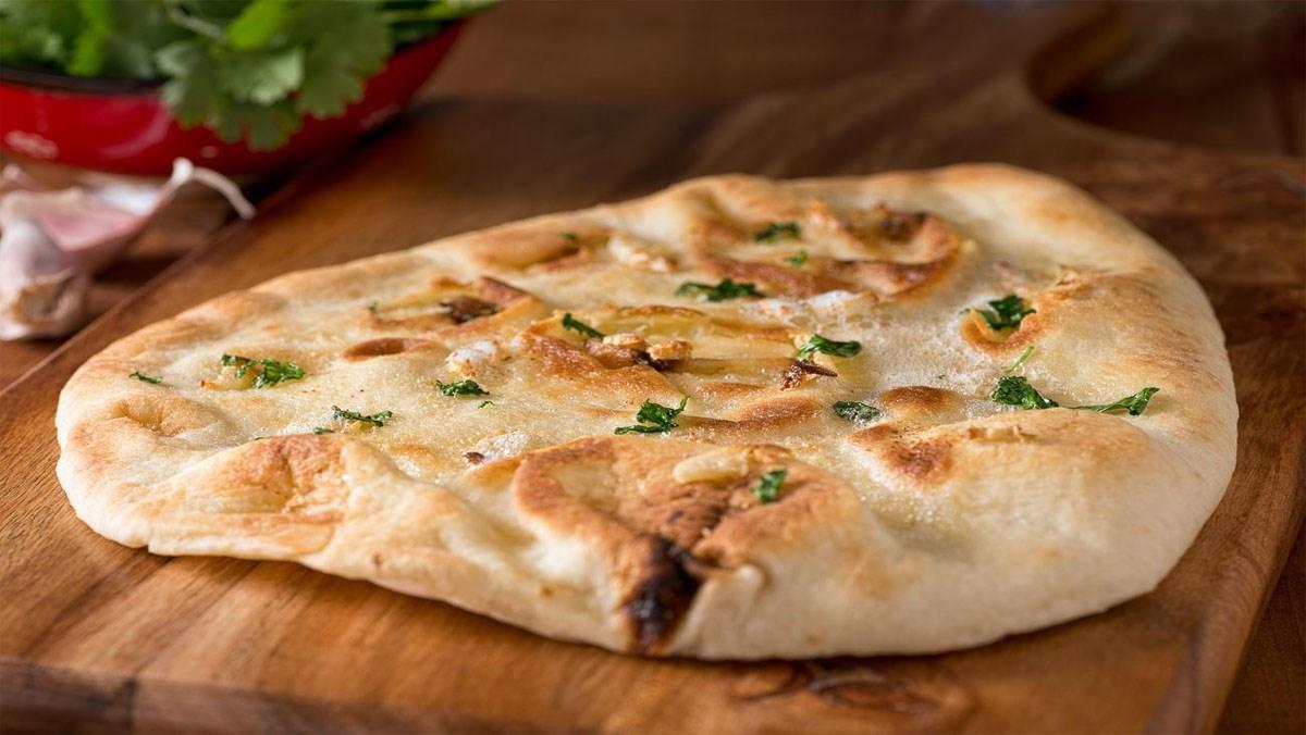 Bánh mì Naan làm từ bột mì nướng áp vào thành của lò đất sét truyền thống