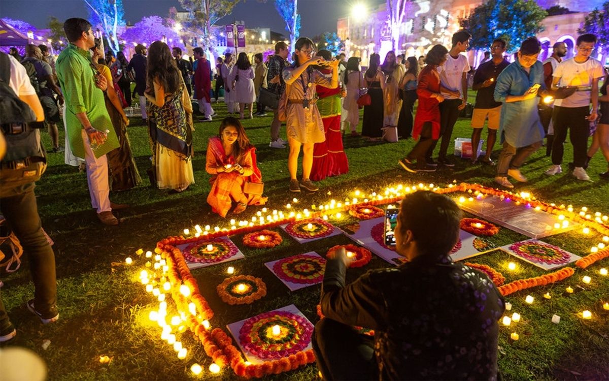Locals gather around lamps and outdoor Diwali art