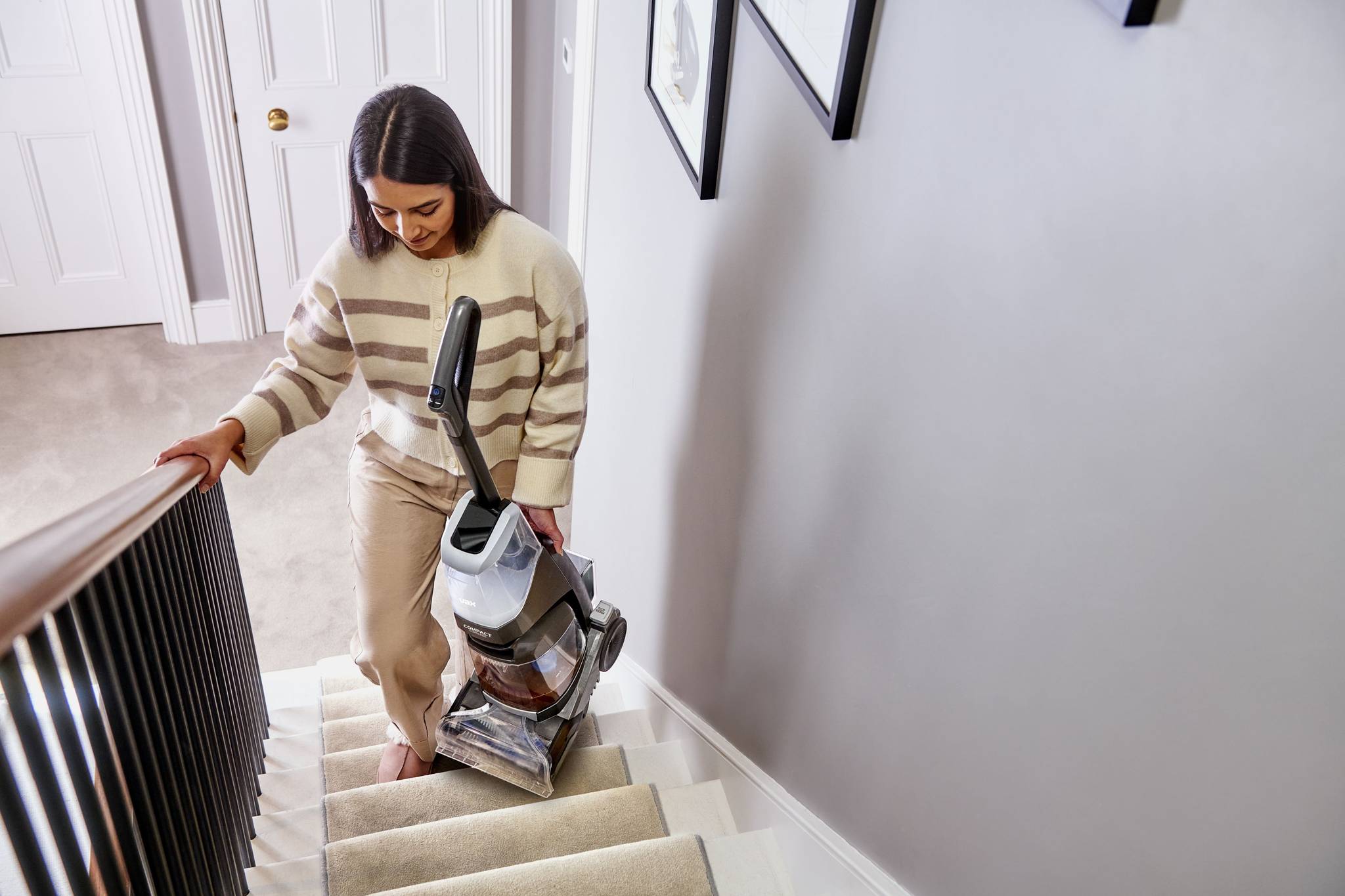 ONEPWR Compact Cordless Carpet Cleaner being carried up stairs