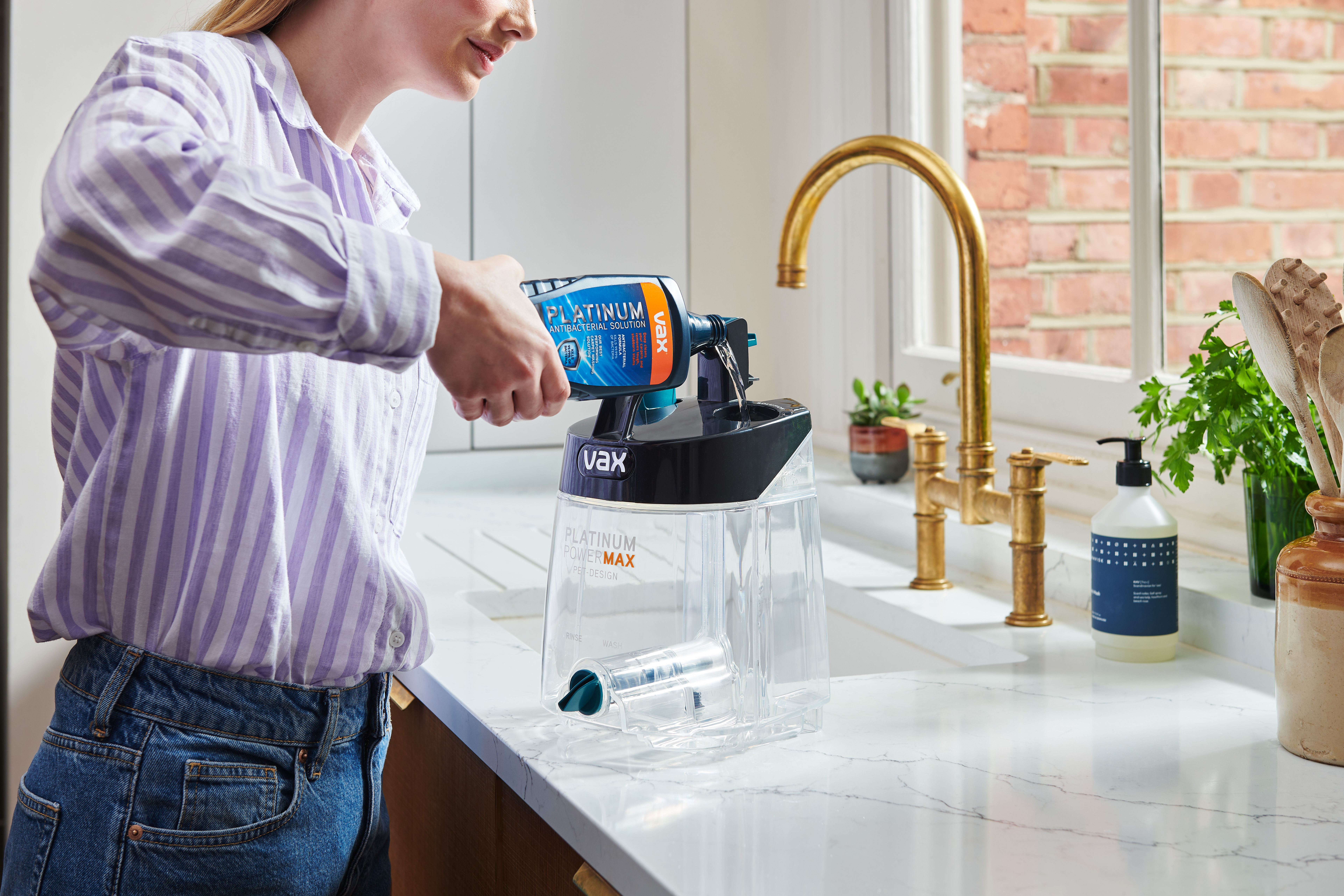 Pouring carpet cleaning solution into the solution tank of the VAX Platinum Power Max Pet-Design