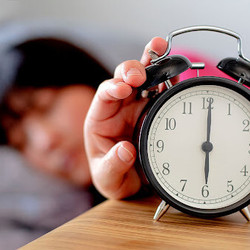 woman hitting alarm clock