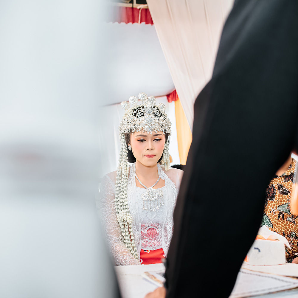 Flower girl and ring bearer walking down wedding aisle with adorable innocent expressions holding basket and pillow