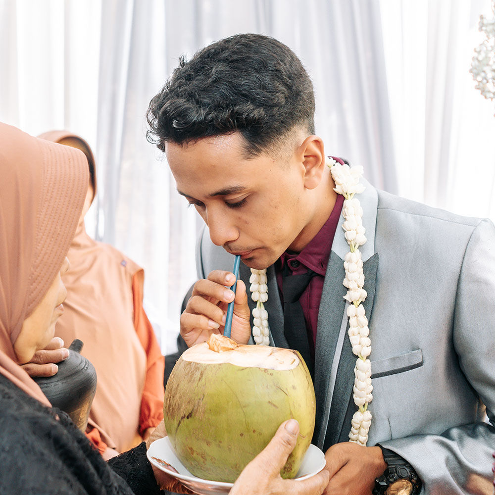 Groom wiping tears of joy from brides eyes during emotional first look moment with soft natural lighting
