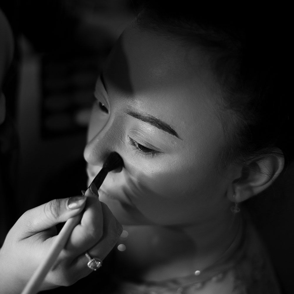Natural candid moment of bride laughing joyfully while surrounded by bridesmaids in matching pastel colored dresses