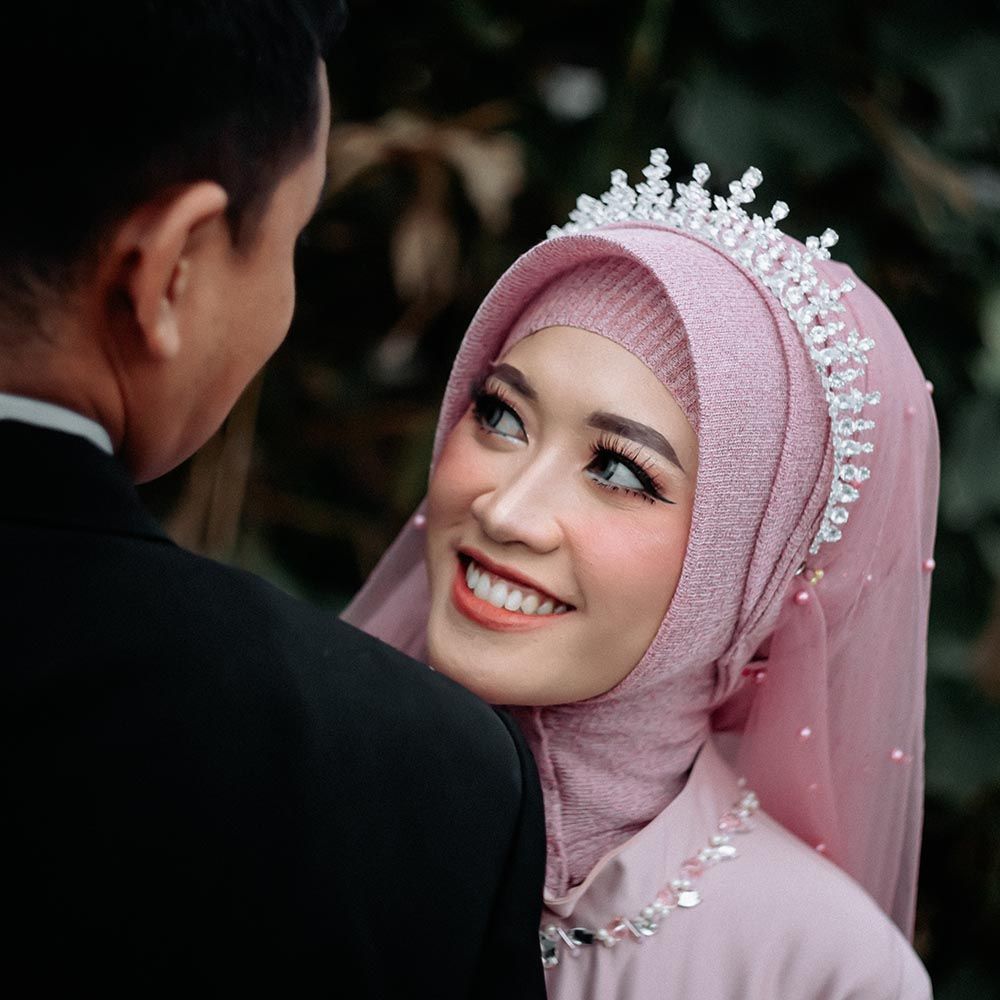 Couple sharing first dance at wedding reception under sparkling disco ball with romantic lighting and guests watching