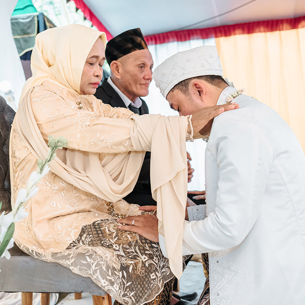 Family blessing ceremony with parents giving emotional prayers to newlywed couple in traditional cultural wedding attire
