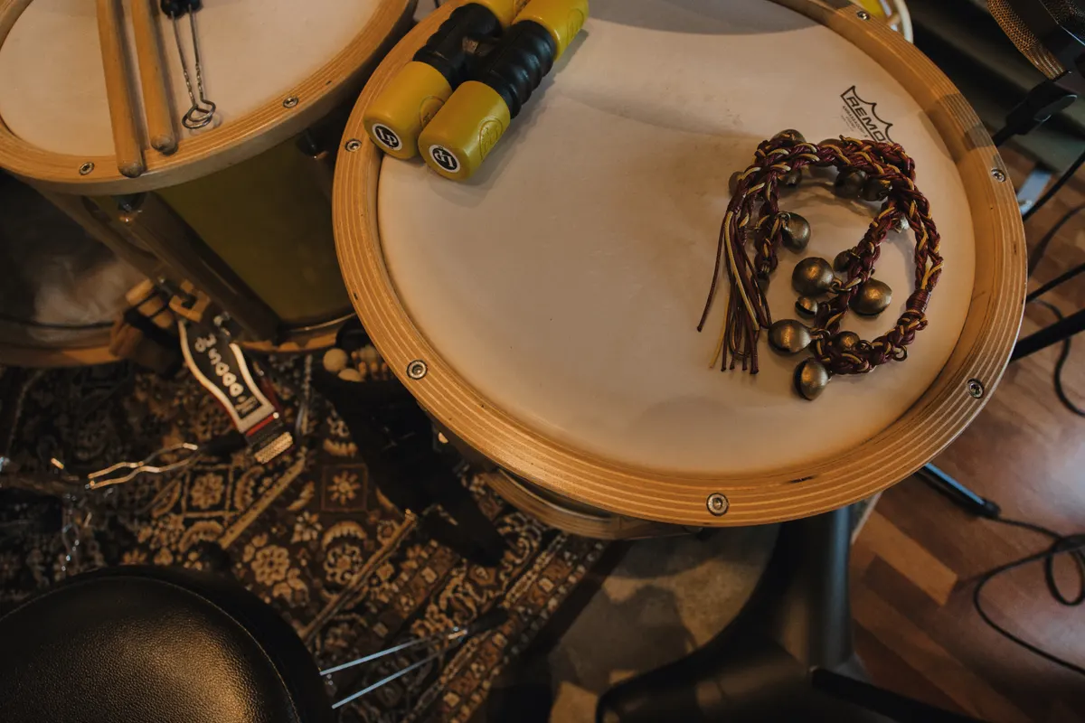 Sleigh bells on a drum head, shakers and sticks on the studio rug