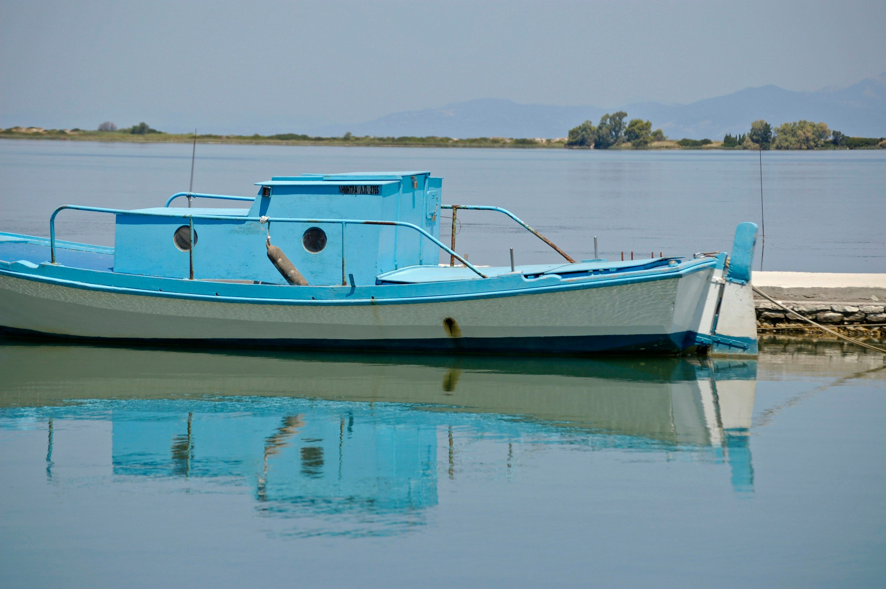 white and blue boat on water during daytime