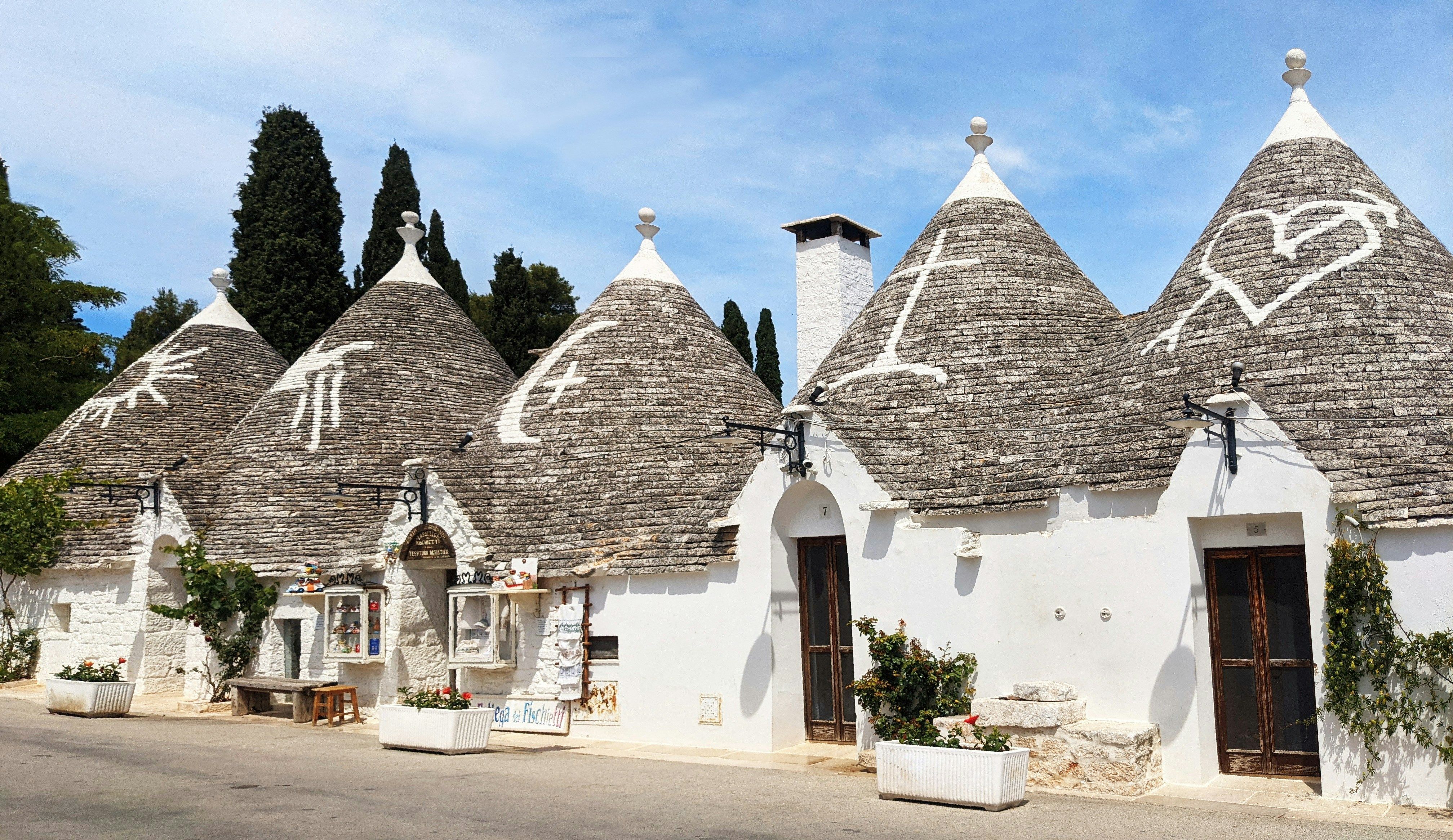 a row of white houses with thatched roofs
