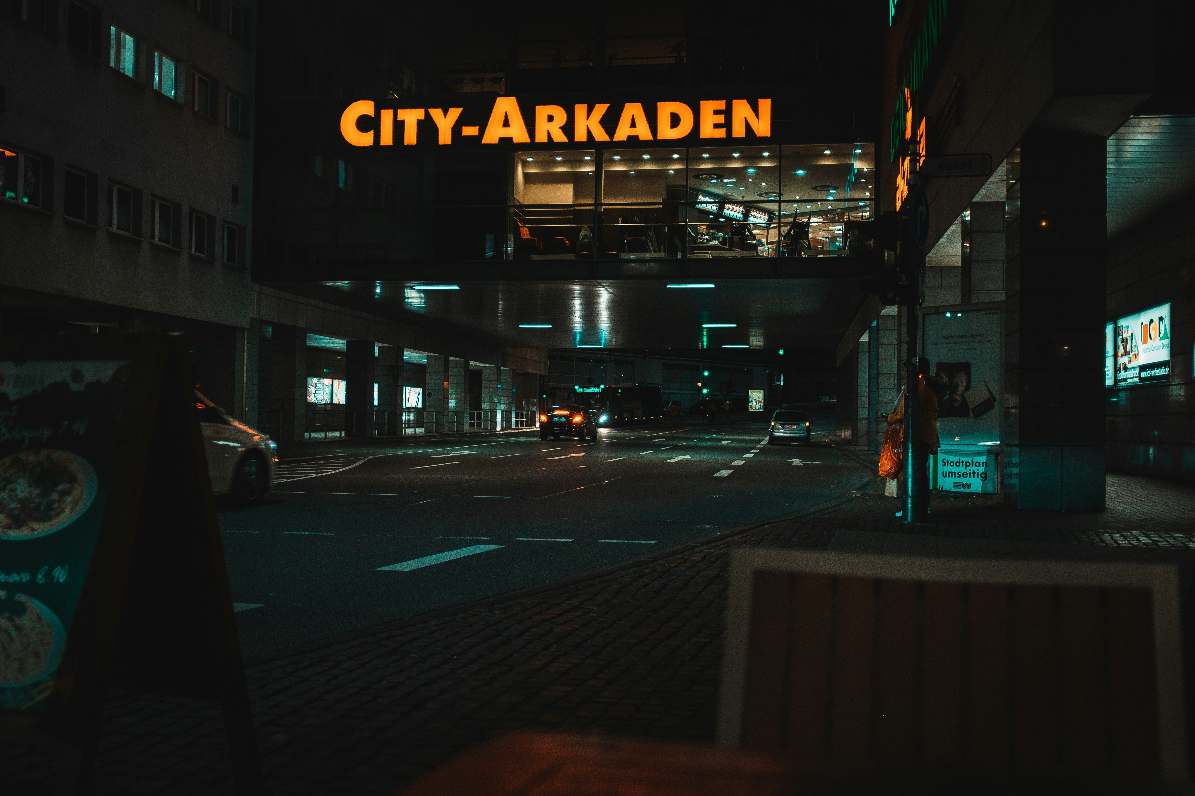 a city - arkaden sign is lit up at night