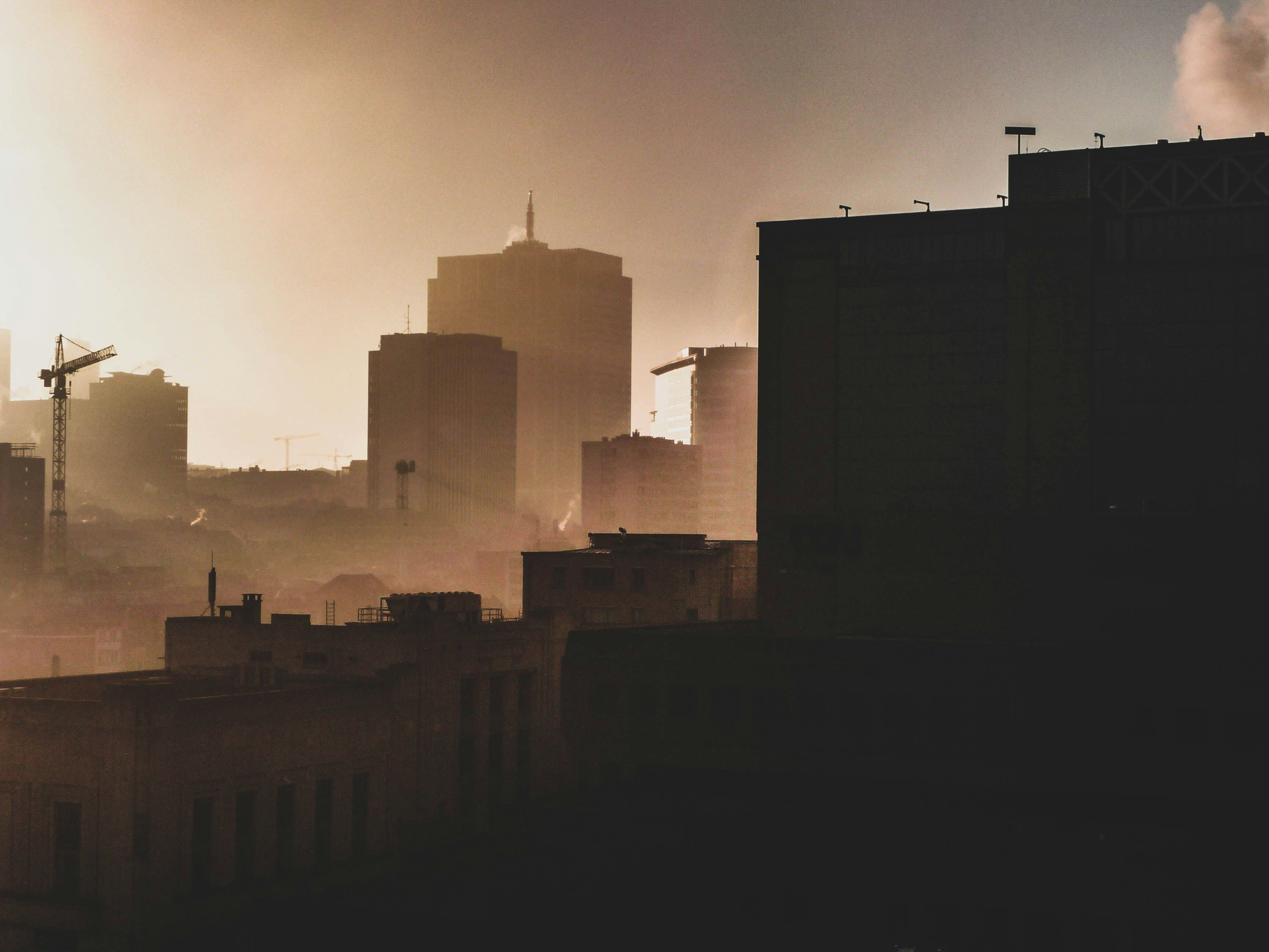 a view of a city skyline with smoke coming out of it