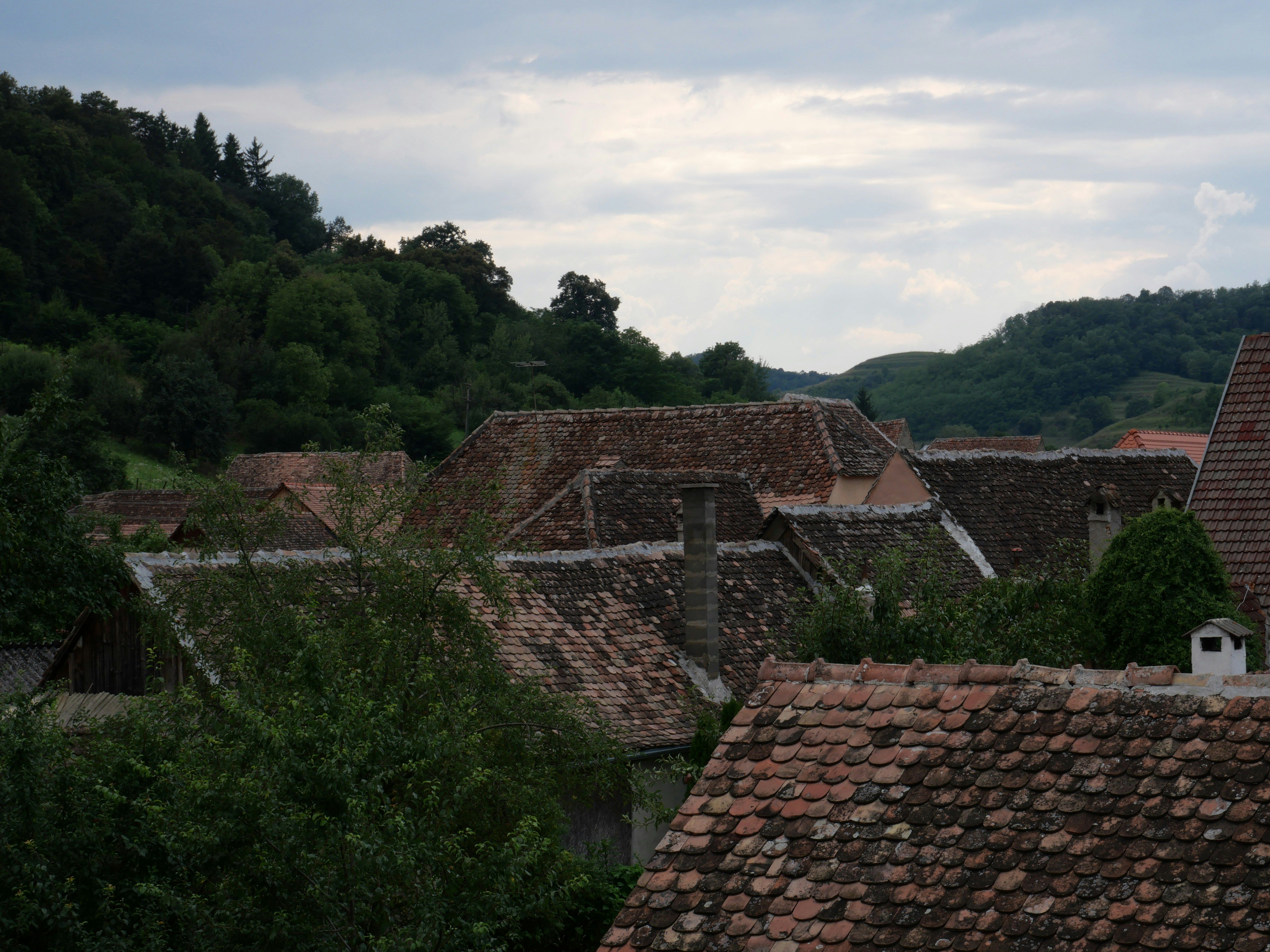 Roofs of old village houses under cloudy sky