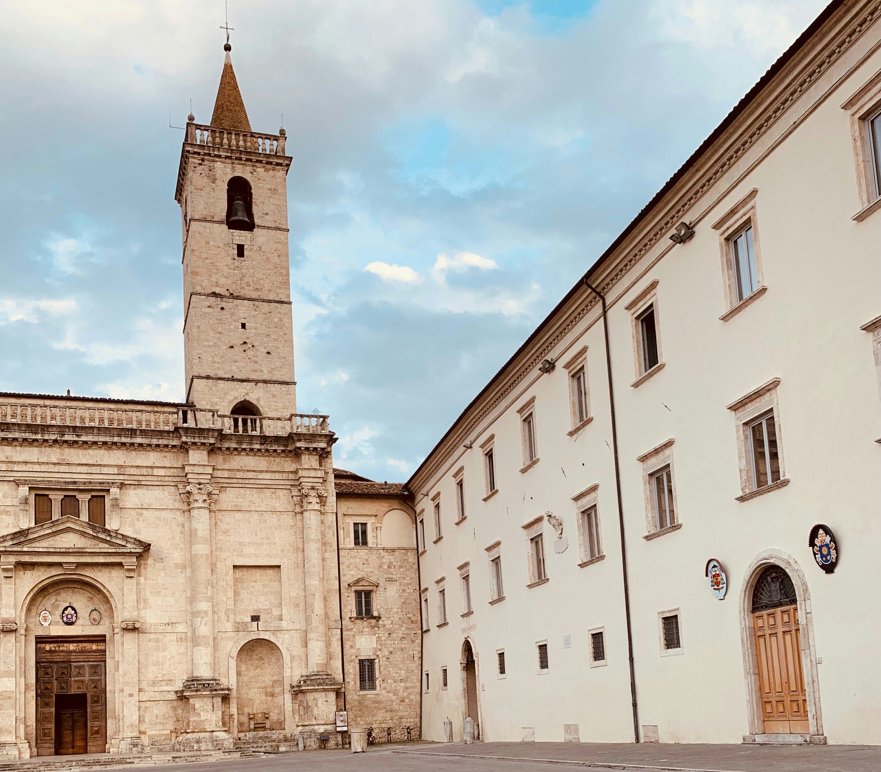A historic church with a tall bell tower and courtyard.