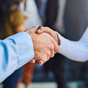 Socios estrechando manos en acuerdo de colaboración