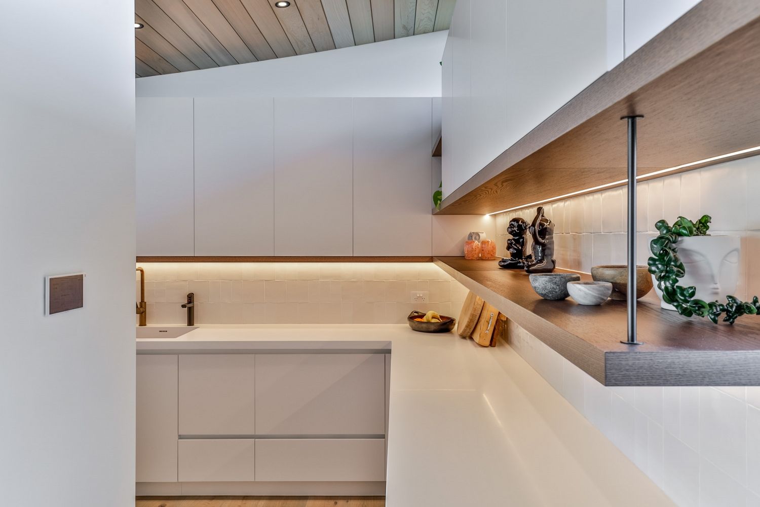 Detailed view of cabinetry craftsmanship and hardware finishes towards the scullery.