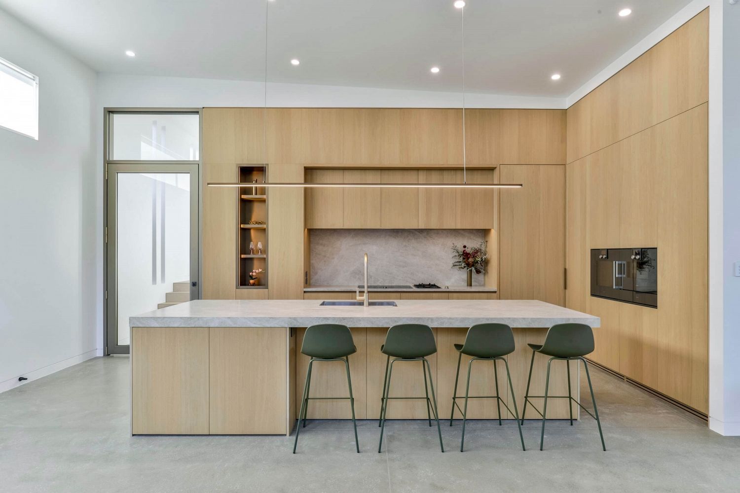 Minimalist timber kitchen with full-height joinery and concealed scullery door