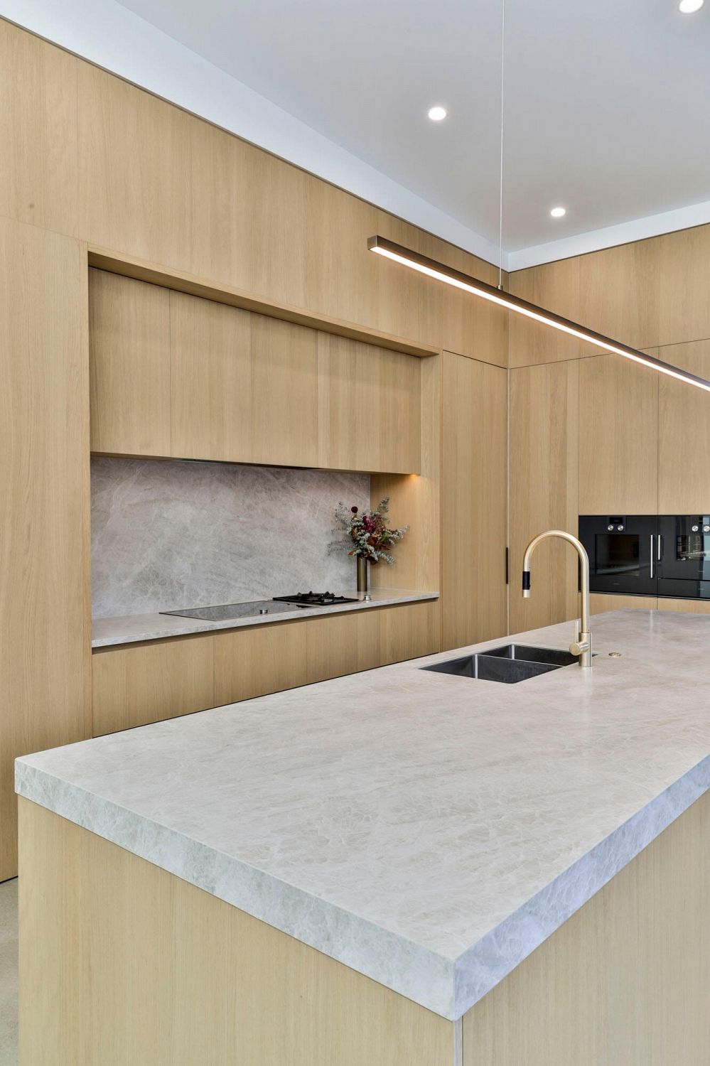 Timber-clad kitchen integrated into open living and dining space