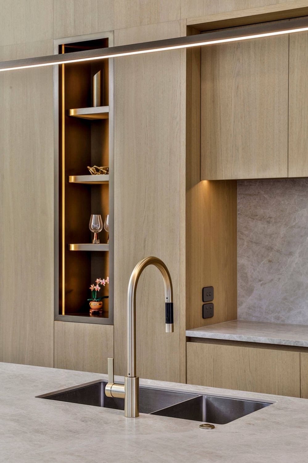 Aged brass open shelving niche integrated into timber joinery