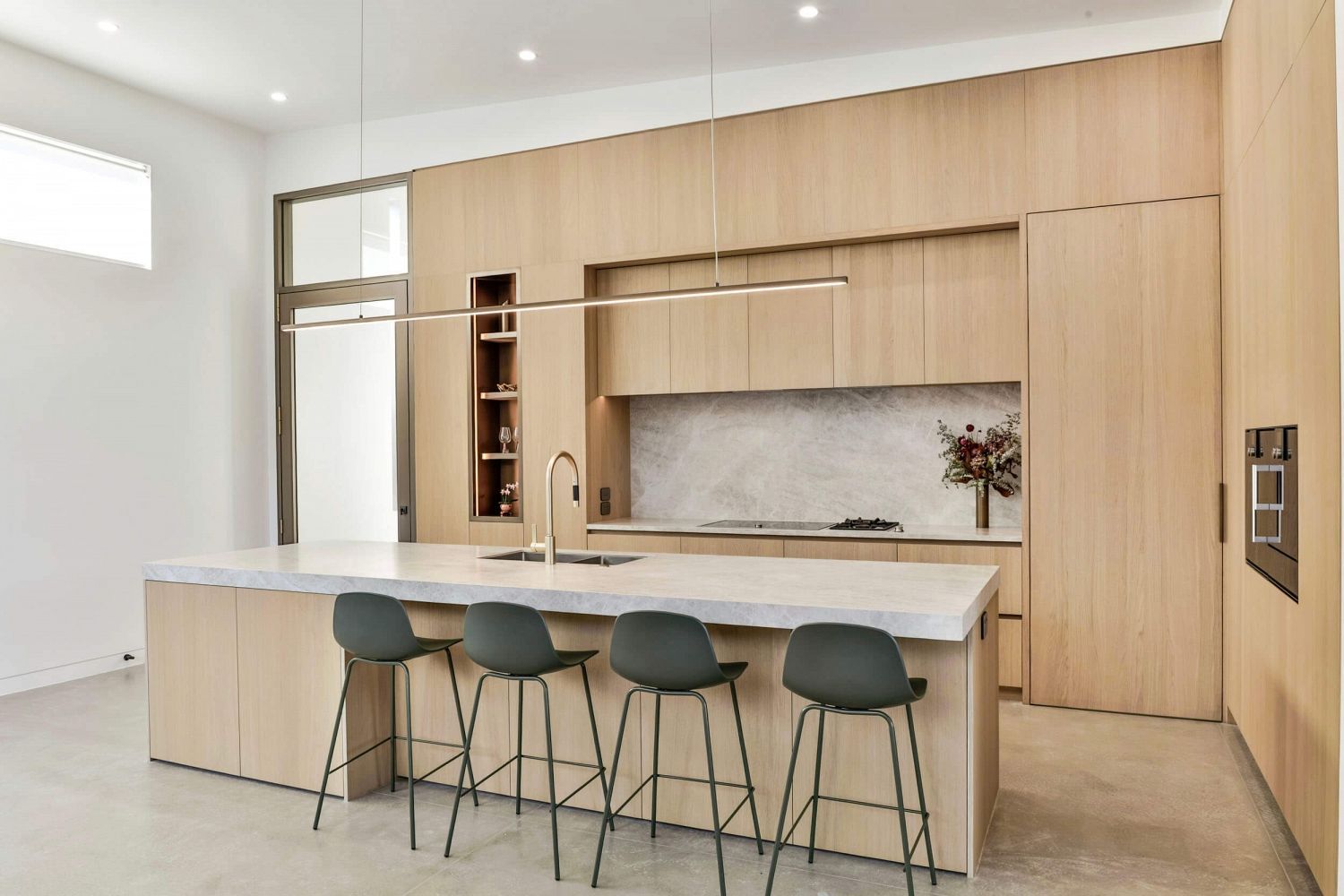 Timber joinery wrapping kitchen in continuous architectural form
