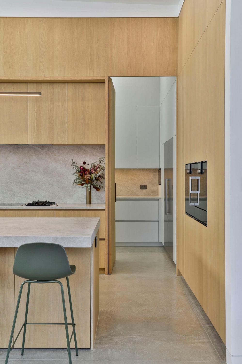 Scullery entrance open from kitchen, showing integrated storage and workspace beyond