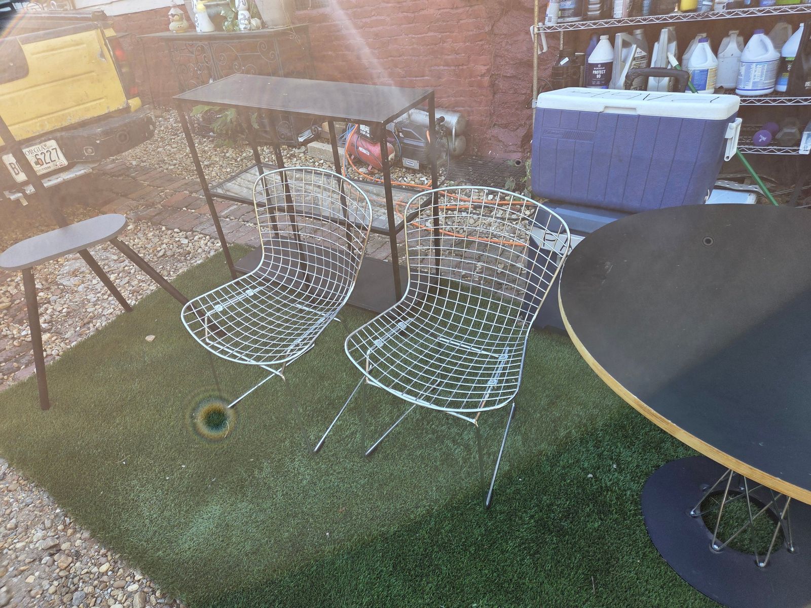 Table Mid-Century Modern Round Table $90. 2 Wire Chairs $45 ea 5 x 10 carpet 85. Mid-century modern dining a round table, two wire side chairs. The table has a black laminate top with an exposed plywood edge and a black metal pedestal base with wire accents. The two chairs are constructed from chrome-plated steel wire with a sled base design. — photo 4