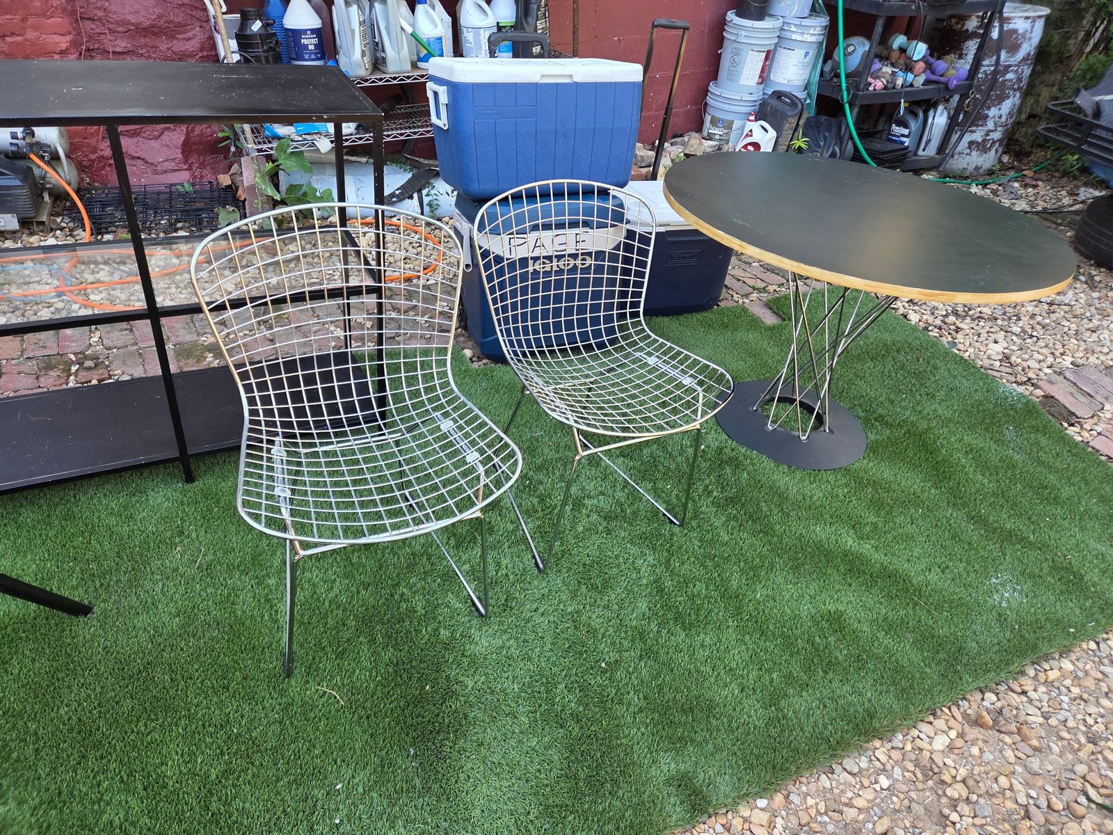 Table Mid-Century Modern Round Table $90. 2 Wire Chairs $45 ea 5 x 10 carpet 85. Mid-century modern dining a round table, two wire side chairs. The table has a black laminate top with an exposed plywood edge and a black metal pedestal base with wire accents. The two chairs are constructed from chrome-plated steel wire with a sled base design. — photo 3